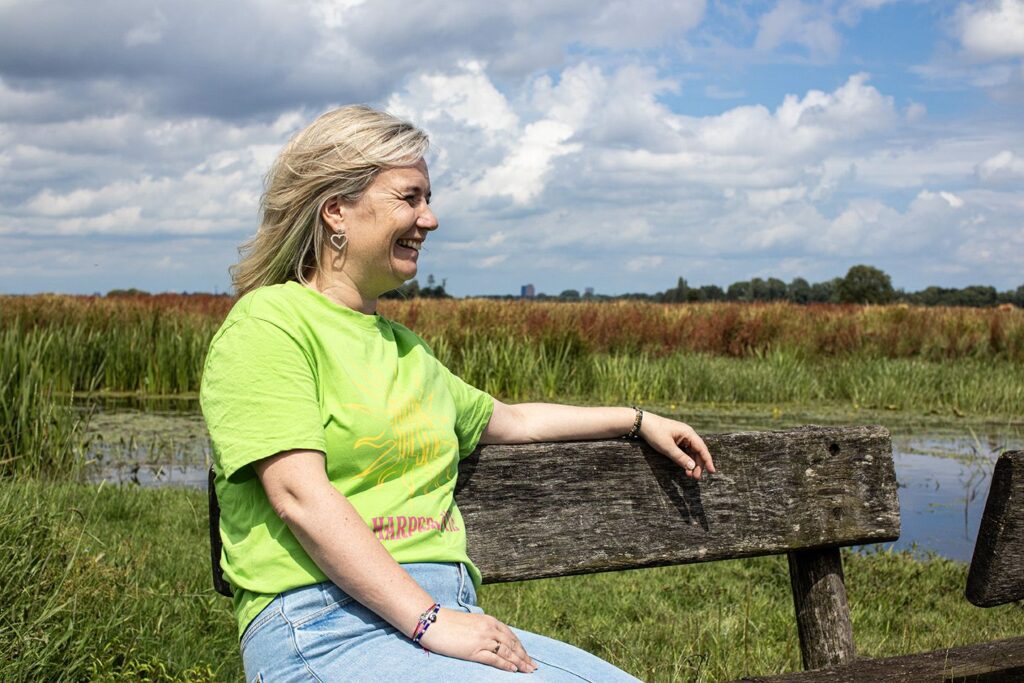 Agnes zittend op een bankje in de natuur